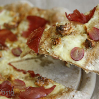 Weiße Walnusspizza mit Bresaola und roten Weintrauben